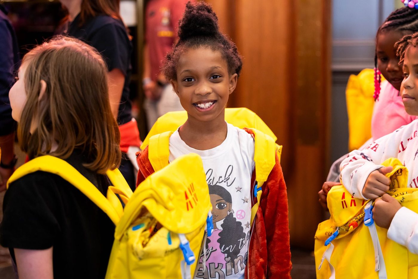 Aku yellow backpack giveaway at the I PROMISE School